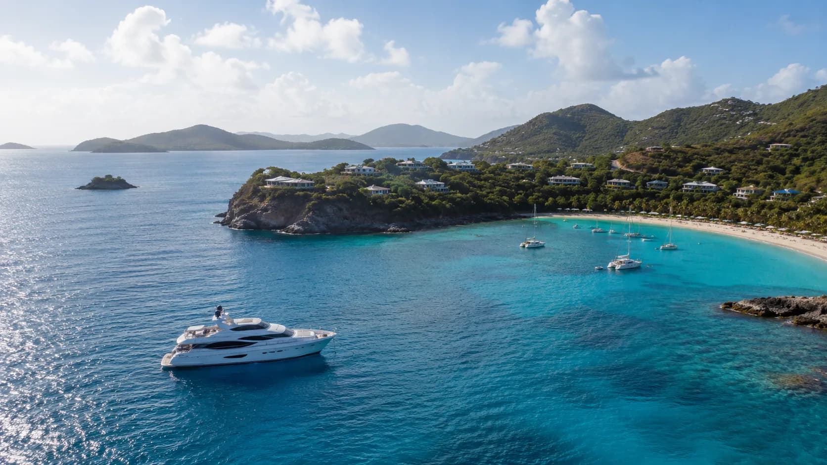 Motor yacht at anchor in a turquoise Caribbean bay ringed by green hills